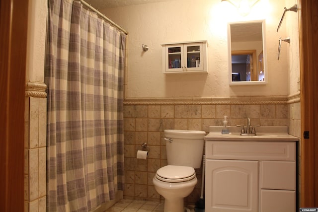 1540 Manor Dr, Casper, WY 82609 - bathroom with vanity, tile walls, wainscoting, a shower with shower curtain, and tile patterned flooring