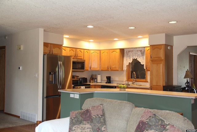 1540 Manor Dr, Casper, WY 82609 - kitchen with appliances with stainless steel finishes, light countertops, a textured ceiling, and recessed lighting