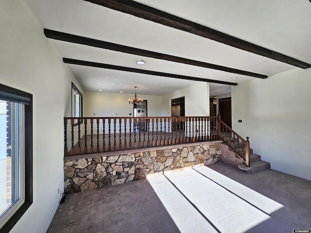918 E 27th Ave, Torrington, WY 82240 - unfurnished living room with carpet flooring, beamed ceiling, a chandelier, and stairway