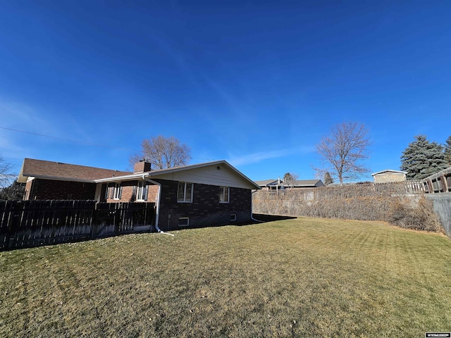 918 E 27th Ave, Torrington, WY 82240 - rear view of house featuring brick siding, a chimney, and a fenced backyard