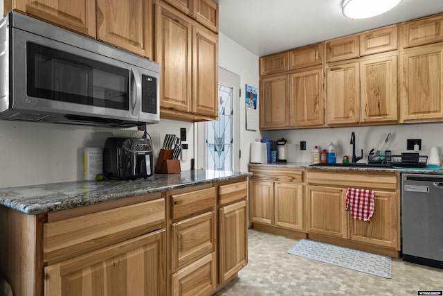 1831 Glendale Ave, Casper, WY 82601 - kitchen with stainless steel appliances, dark stone counters, and light floors