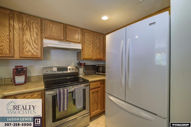 3477 Trappers Trl, Casper, WY 82604 - kitchen featuring stainless steel appliances, under cabinet range hood, light countertops, brown cabinetry, and recessed lighting