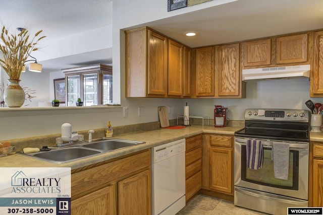 3477 Trappers Trl, Casper, WY 82604 - kitchen featuring under cabinet range hood, dishwasher, stainless steel range with electric stovetop, light countertops, and brown cabinets