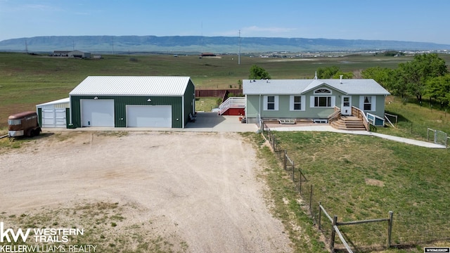 7459 Geary Dome Rd, Evansville, WY 82636 - view of front of home with an outdoor structure, a detached garage, a rural view, a mountain view, and dirt driveway
