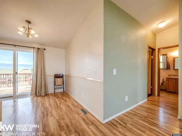 7459 Geary Dome Rd, Evansville, WY 82636 - spare room with vaulted ceiling, light wood finished floors, and a chandelier