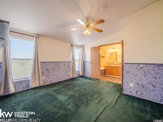 7459 Geary Dome Rd, Evansville, WY 82636 - unfurnished bedroom with carpet, wainscoting, vaulted ceiling, a ceiling fan, and ensuite bath