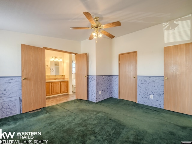 7459 Geary Dome Rd, Evansville, WY 82636 - unfurnished bedroom with wainscoting, carpet floors, ceiling fan, and connected bathroom