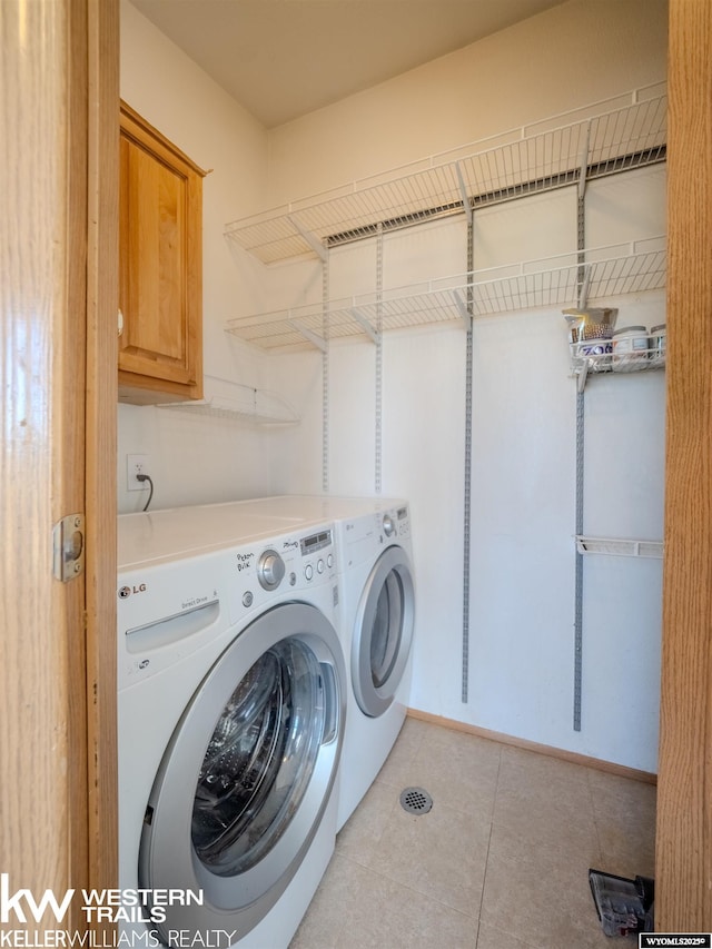 7459 Geary Dome Rd, Evansville, WY 82636 - laundry room with cabinet space, independent washer and dryer, and light tile patterned floors