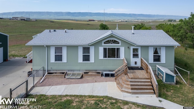 7459 Geary Dome Rd, Evansville, WY 82636 - view of front of property with a shingled roof, a mountain view, and a patio area