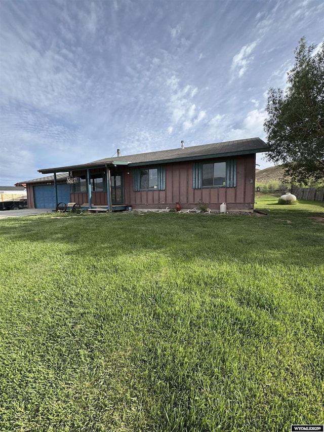 1512 Highview Dr, Dubois, WY 82513 - back of property featuring a garage, a yard, driveway, and board and batten siding