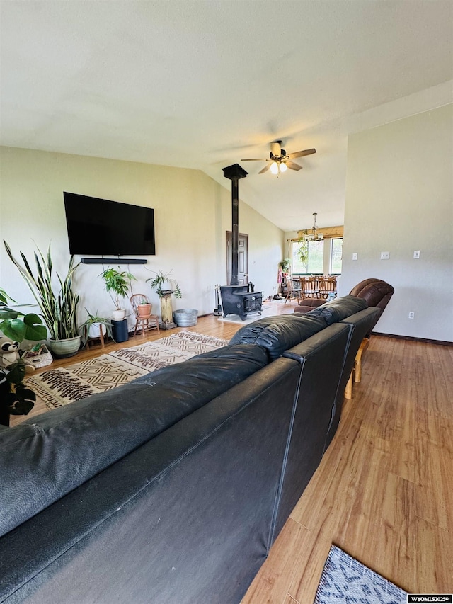1512 Highview Dr, Dubois, WY 82513 - living room featuring a wood stove, vaulted ceiling, light wood-type flooring, a ceiling fan, and a chandelier