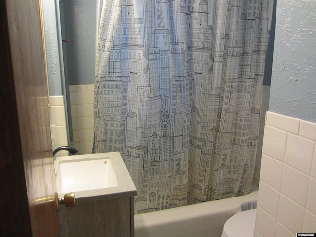 716 S 6th, Douglas, WY 82633 - bathroom featuring tile walls, vanity, shower / bathtub combination with curtain, a wainscoted wall, and a textured wall