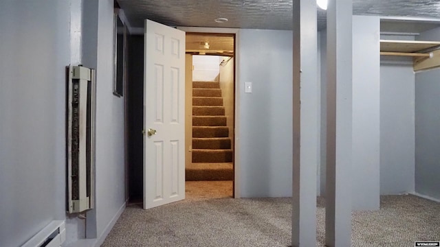1041 S Mckinley St, Casper, WY 82601 - finished basement featuring a baseboard heating unit, carpet flooring, stairway, and a textured ceiling