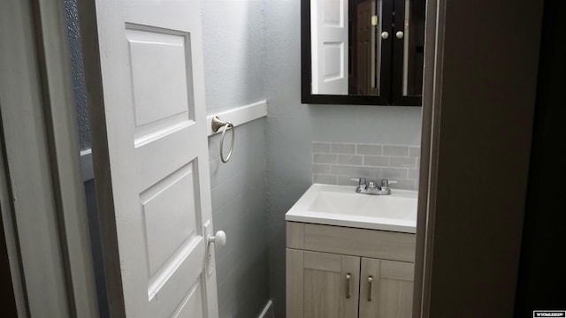 1041 S Mckinley St, Casper, WY 82601 - half bathroom featuring vanity, tasteful backsplash, and tile walls