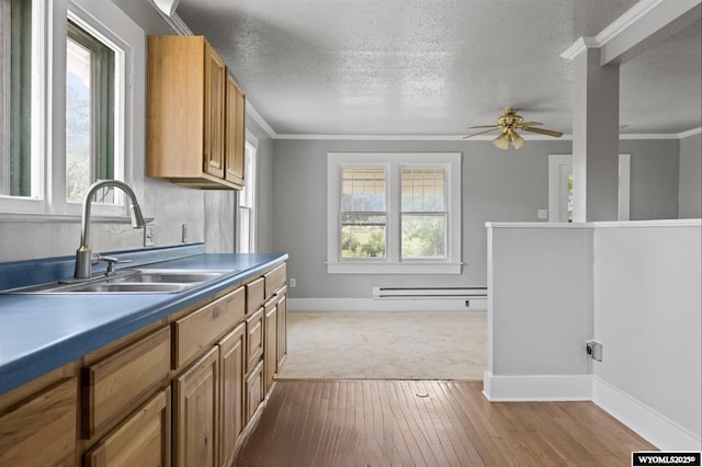 1041 S Mckinley St, Casper, WY 82601 - kitchen with a ceiling fan, wood-type flooring, a baseboard heating unit, brown cabinets, and a textured ceiling