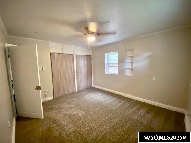 1041 S Mckinley St, Casper, WY 82601 - unfurnished bedroom with dark carpet, a closet, and ceiling fan