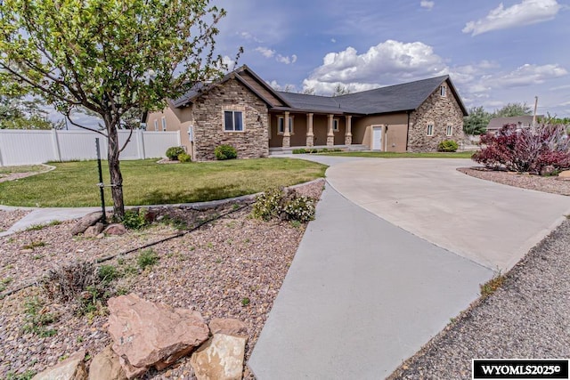 1011 Heritage Cove Dr, Lyman, WY 82937 - view of front of home featuring stone siding, curved driveway, and stucco siding