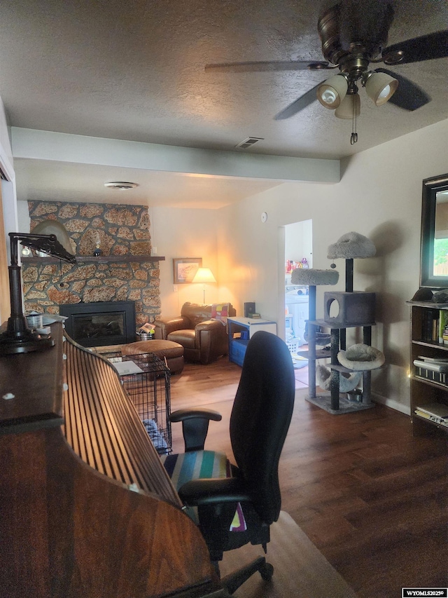 828 Fort St, Buffalo, WY 82834 - office space featuring wood finished floors, a ceiling fan, a stone fireplace, and a textured ceiling