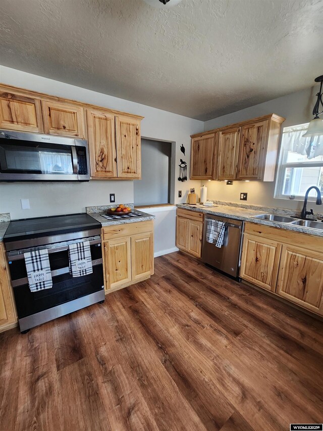 828 Fort St, Buffalo, WY 82834 - kitchen with appliances with stainless steel finishes, dark wood-style flooring, a textured ceiling, and light countertops
