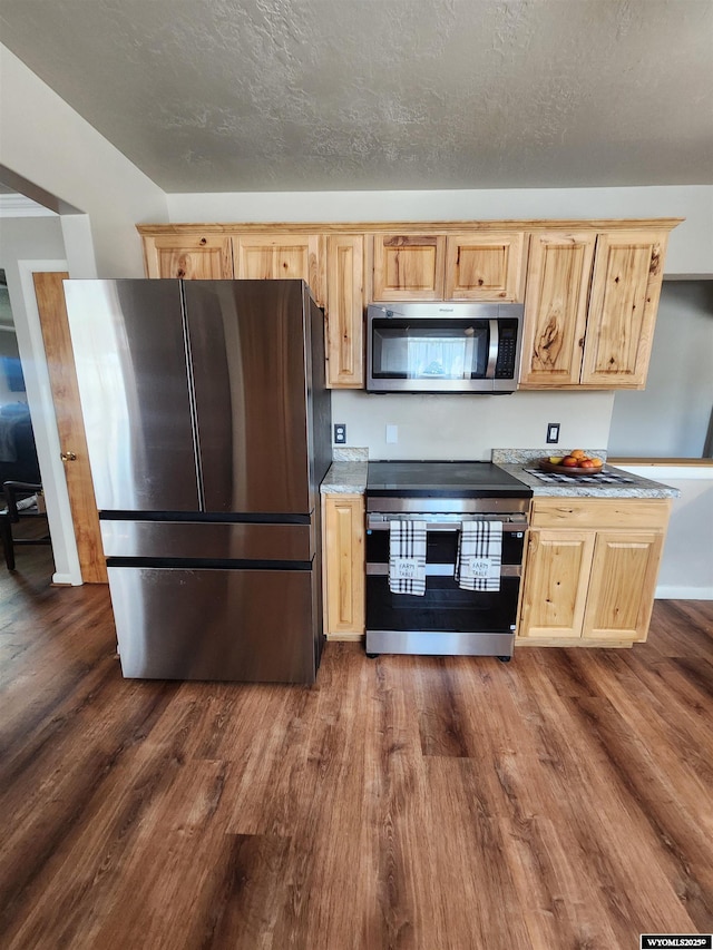 828 Fort St, Buffalo, WY 82834 - kitchen with stainless steel appliances, light brown cabinets, dark wood-style flooring, and light countertops
