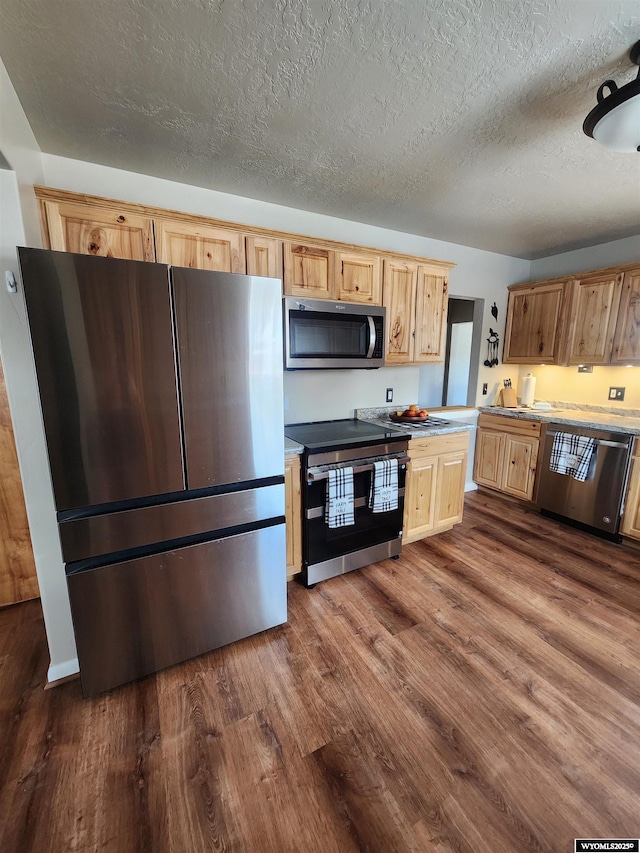828 Fort St, Buffalo, WY 82834 - kitchen featuring appliances with stainless steel finishes, dark wood finished floors, light brown cabinetry, a textured ceiling, and light countertops