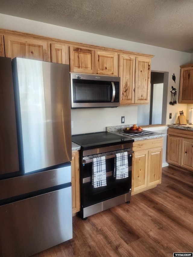 828 Fort St, Buffalo, WY 82834 - kitchen with stainless steel appliances, dark wood-style floors, light brown cabinets, light countertops, and a textured ceiling