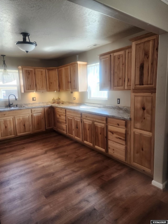 828 Fort St, Buffalo, WY 82834 - kitchen featuring plenty of natural light, dark wood-style floors, light countertops, and a textured ceiling