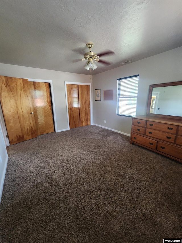 828 Fort St, Buffalo, WY 82834 - unfurnished bedroom featuring multiple closets, carpet, a textured ceiling, and ceiling fan