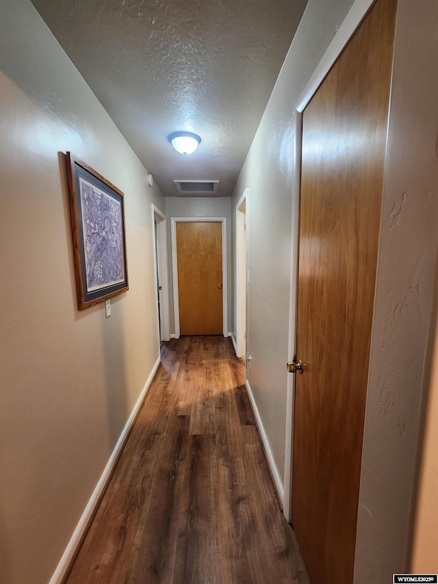 828 Fort St, Buffalo, WY 82834 - corridor with wood finished floors, a textured ceiling, and attic access