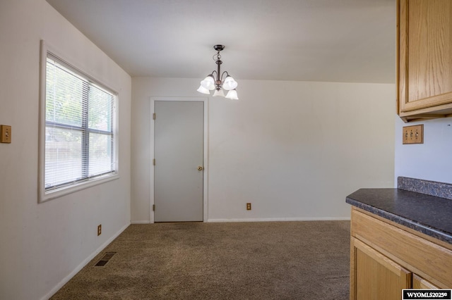 2841 E 4th St, Casper, WY 82609 - unfurnished dining area featuring a chandelier and carpet flooring