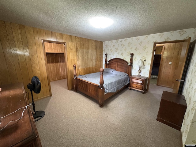 1501 N Federal Blvd, Riverton, WY 82501 - bedroom featuring wallpapered walls, a textured ceiling, wooden walls, and light colored carpet