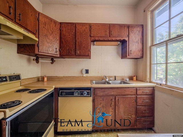 719 E 4th St, Casper, WY 82601 - kitchen featuring dishwasher, electric range, under cabinet range hood, light countertops, and brown cabinets