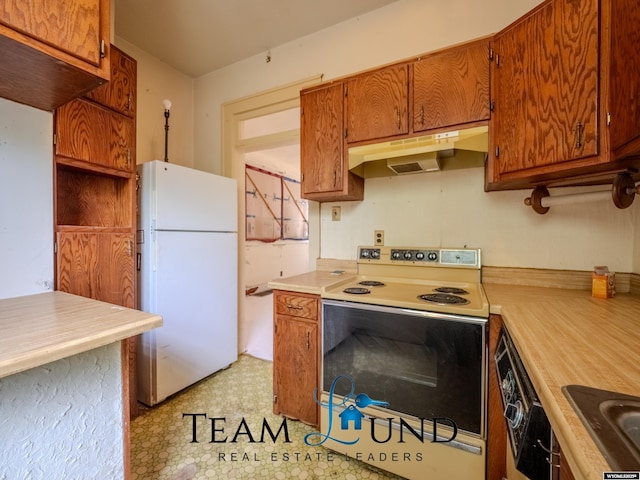 719 E 4th St, Casper, WY 82601 - kitchen featuring white appliances, under cabinet range hood, light countertops, brown cabinetry, and light flooring