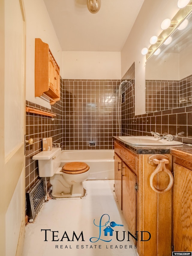 719 E 4th St, Casper, WY 82601 - full bathroom with tile walls, vanity, decorative backsplash, and tub / shower combination