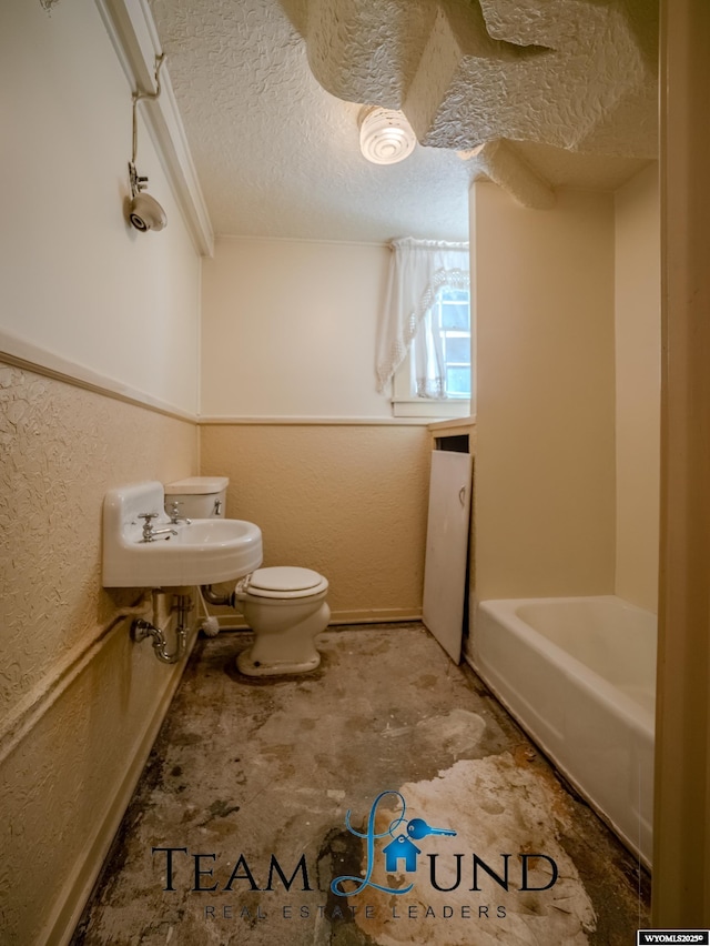 719 E 4th St, Casper, WY 82601 - bathroom featuring a textured ceiling, a textured wall, and a bath