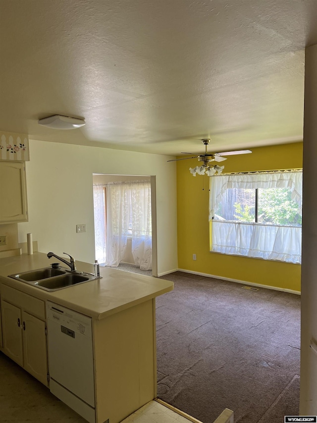 133 Shady Ln, Evanston, WY 82930 - kitchen with white dishwasher, light countertops, carpet floors, white cabinets, and a peninsula