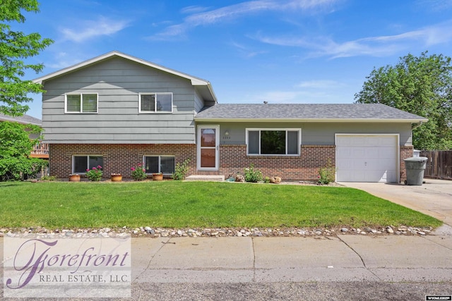 2240 E 17th St, Casper, WY 82609 - tri-level home featuring a garage, a front lawn, concrete driveway, brick siding, and roof with shingles