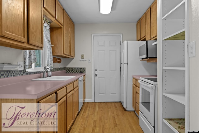 2240 E 17th St, Casper, WY 82609 - kitchen with white appliances, light wood finished floors, and brown cabinetry