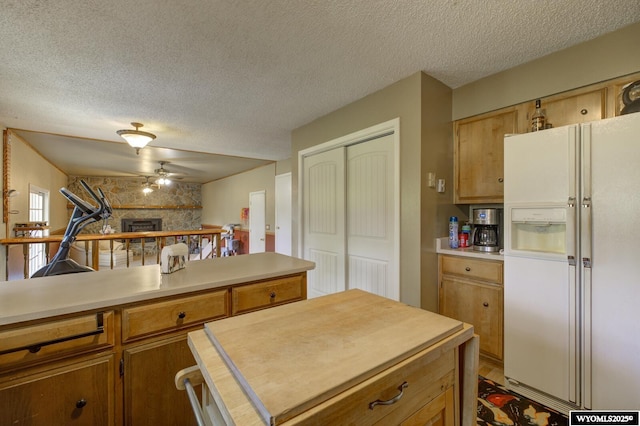 2203 W 42nd St, Casper, WY 82604 - kitchen featuring white refrigerator with ice dispenser, a fireplace, a textured ceiling, light countertops, and a ceiling fan