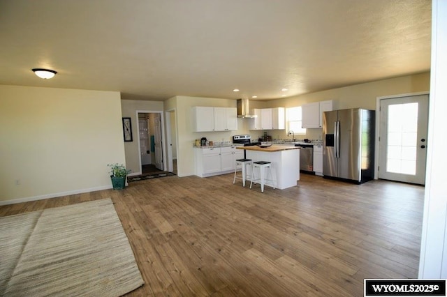 380 S-A Rd, Morrill, NE 69358 - kitchen with appliances with stainless steel finishes, open floor plan, a center island, white cabinetry, and wall chimney range hood