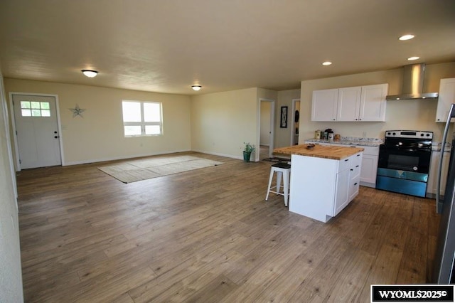 380 S-A Rd, Morrill, NE 69358 - kitchen with electric range, wall chimney exhaust hood, wood counters, white cabinets, and a breakfast bar
