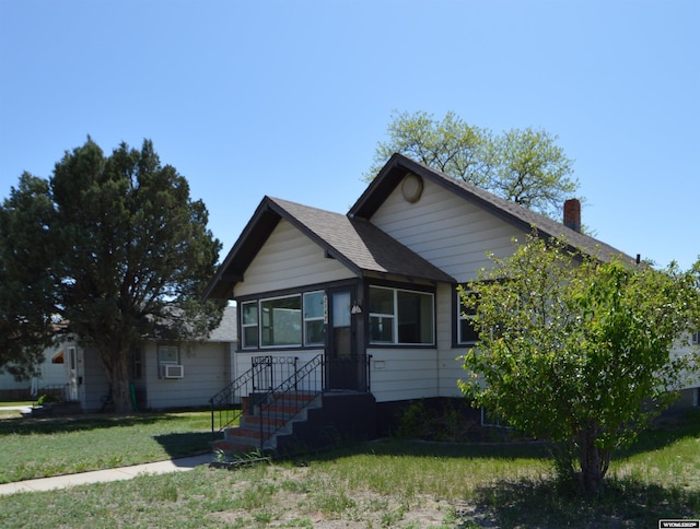 2142 W C St, Torrington, WY 82240 - view of front of home with a front lawn, cooling unit, and a chimney