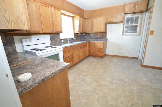 2142 W C St, Torrington, WY 82240 - kitchen featuring white range with electric cooktop, stone floors, dark countertops, and backsplash