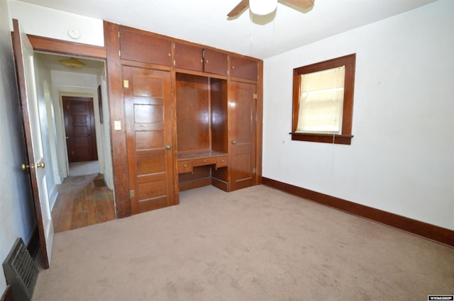 2142 W C St, Torrington, WY 82240 - unfurnished bedroom featuring light colored carpet, a desk, a closet, and ceiling fan
