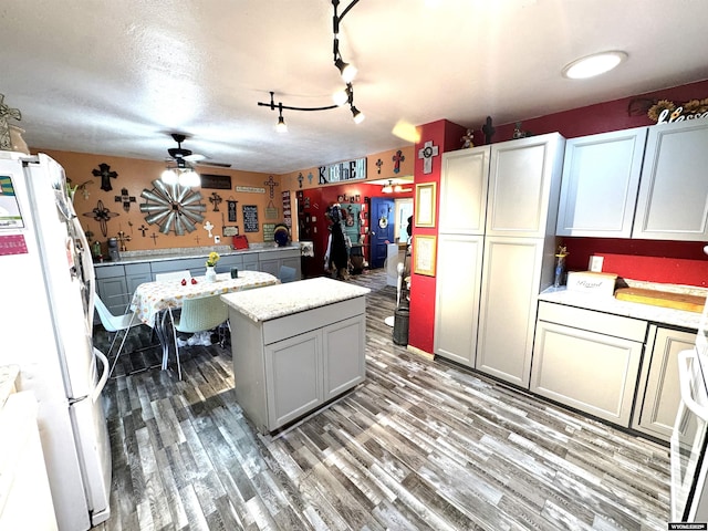 327 S Iowa Ave, Guernsey, WY 82214 - kitchen with freestanding refrigerator, a kitchen island, light countertops, light wood-style floors, and a ceiling fan