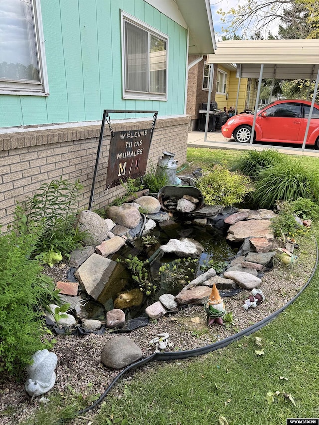 327 S Iowa Ave, Guernsey, WY 82214 - exterior view of brick siding and a small pond