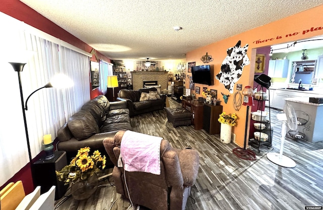 327 S Iowa Ave, Guernsey, WY 82214 - living area with a textured ceiling, wood finished floors, a fireplace, and plenty of natural light