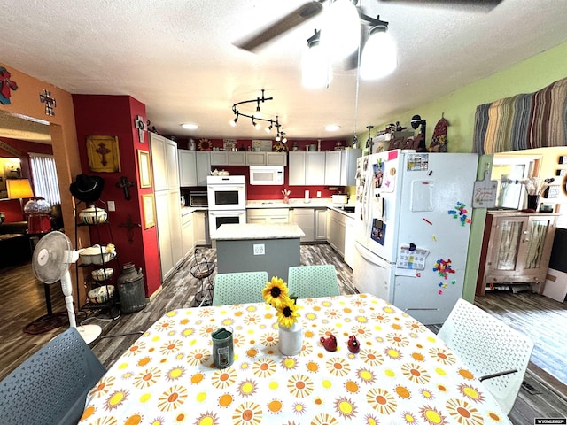 327 S Iowa Ave, Guernsey, WY 82214 - kitchen with white appliances, dark wood-style floors, a kitchen island, light countertops, and a ceiling fan