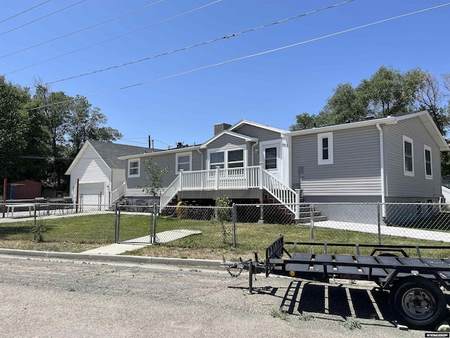 703 Randolph St, Rock Springs, WY 82901 - manufactured / mobile home with a fenced front yard, a chimney, a wooden deck, a garage, and stairway
