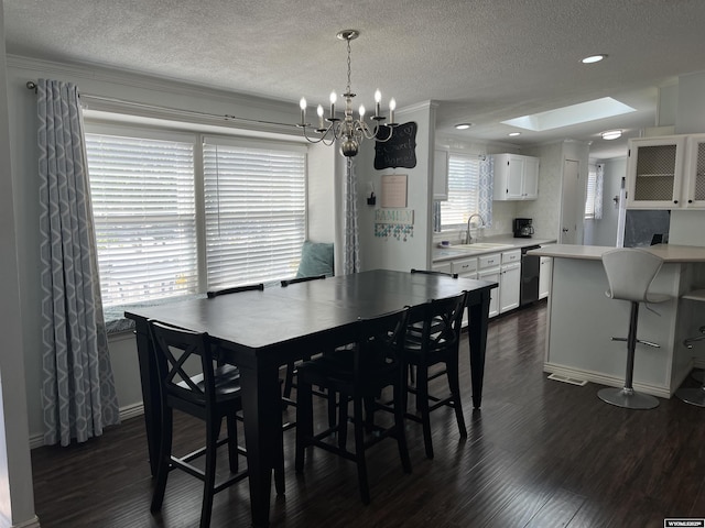 703 Randolph St, Rock Springs, WY 82901 - dining area with dark wood-style flooring, a textured ceiling, a chandelier, a skylight, and recessed lighting
